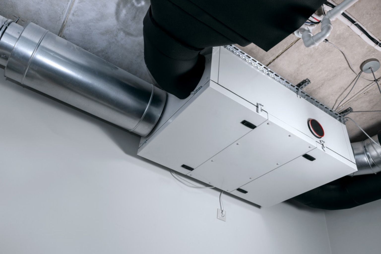 Ventilationsaggregat med tilsluttede kanaler monteret under et loft
